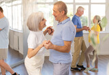 Fototapeta  - Couple of elderly man and elderly woman dancing waltz in studio