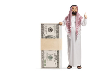 Wall Mural - Bearded saudi arab man leaning on a stack of money and gesturing thumbs up