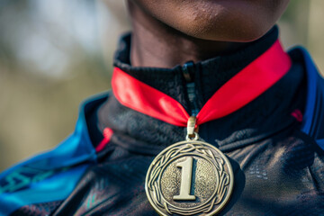 Wall Mural - A winners medal with a number 1 hanging around the neck of a sports person. First place race winner