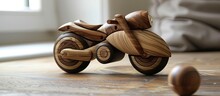 A Small Wooden Toy Motorcycle Is Placed On A Wooden Floor. The Toy Features Intricate Details And Craftsmanship, Resembling A Real Motorcycle. The Contrast Between The Dark Wood Of The Floor And The