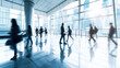 © Fareedoh - Blurred motion of business people walking briskly in a modern corporate office lobby with cityscape background.