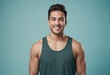A cheerful man in a dark green tank top, his bright smile radiates health and energy.