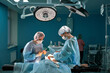 © Georgii - Group of surgeons in operating theater. Medical team performing surgery in operation room.