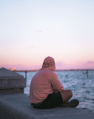 Wall Mural - man sitting on the beach 