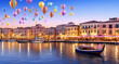 large group of floating balloons over water at dusk