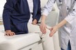 © New Africa - Arthritis symptoms. Doctor examining patient with knee pain in hospital, closeup