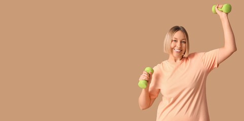 Woman holding dumbbells on beige background with space for text. Weight loss concept