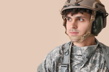 Wall Mural - Young male soldier on beige background, closeup