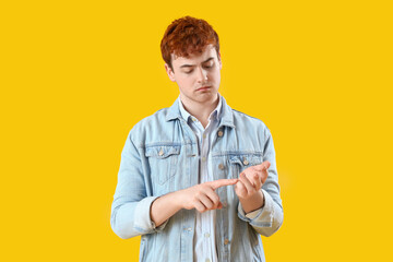 Poster - Young redhead man counting on yellow background