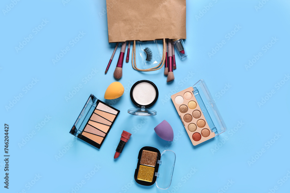 Shopping bag with makeup cosmetics on blue background