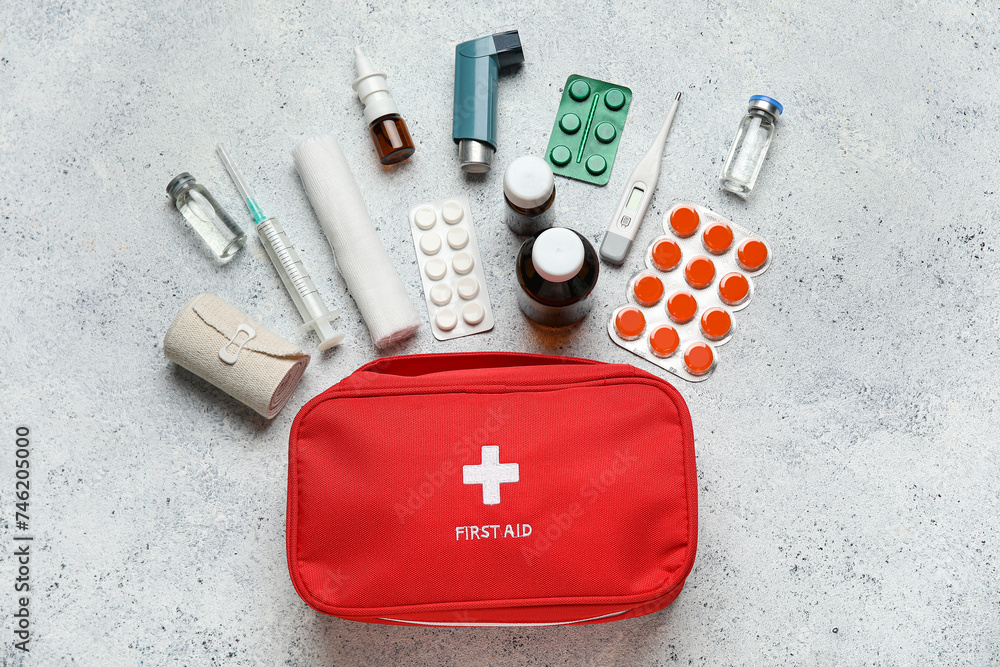 First aid kit with pills on grunge white background