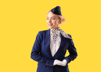 Young stewardess on yellow background