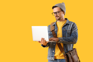 Poster - Young man using laptop on yellow background