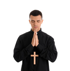 Wall Mural - Young priest with cross paying on white background