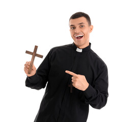 Wall Mural - Young priest pointing at cross on white background