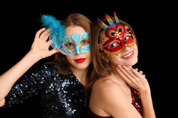 Canvas Print - Beautiful young women in carnival masks on black background