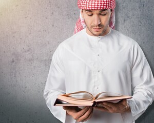Wall Mural - A man holding big holy Quran book in hands