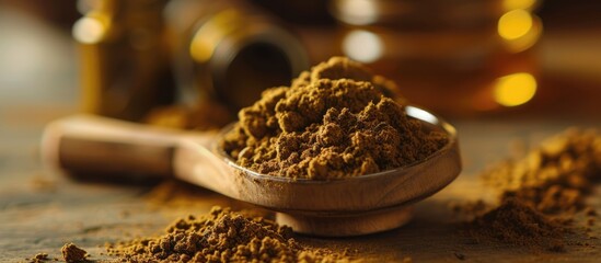 A wooden spoon filled with potent brown powder, likely cannabis hash, is prominently displayed on top of a table. The powder appears to be infused with oil, making it a powerful and potent substance.