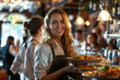 © Kien - Happy waitress serving food to group of friends in pub