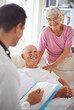 © Mapodile/peopleimages.com - Doctor, senior patient and paperwork in nursing home for wellness, diagnosis and healthcare. Consultation, medical professional and elderly couple for rehabilitation, discussion and positive report