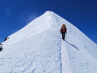 Mountaineer climbing in snowy mountains.