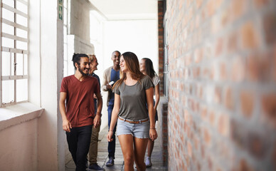 Wall Mural - University, walking and students in a lobby, conversation and speaking with humor or education. Group, men or women in a hallway with discussion or learning with knowledge or college with scholarship