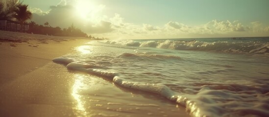 Poster - A sun-kissed sandy beach with gentle waves rolling in from the ocean. The slightly cloudy sky adds to the serene ambiance at the beach.