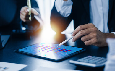 Person analyzing financial figures on tablet, Business person analyzing sales statistics on digital tablet screen at the office desk.