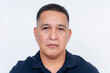 © Mdv Edwards - Stoic and serious expression of a middle-aged Asian man, isolated on a clean white backdrop.