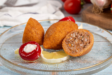 Wall Mural - Stuffed meatballs. Appetizer dishes. Kibbeh on blue wooden background. local name içli köfte. Close up