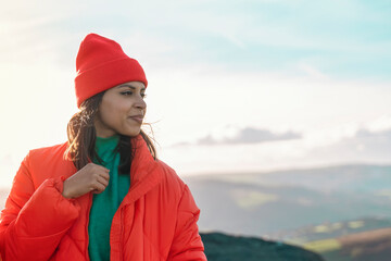 young smiling beautiful woman tourist with backpack hiking and enjoying mountains landscape at sunset in England. A trip to the mountains with a backpack toned image