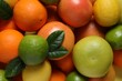 © New Africa - Different fresh citrus fruits and leaves as background, top view