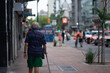 © LVSN - An elderly man walking on the sidewalk with a cane.