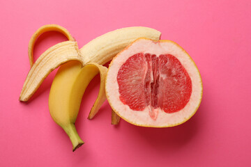 Wall Mural - Banana and half of grapefruit on pink background, flat lay. Sex concept