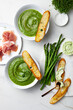 Healthy asparagus, green peas, watercress cream soup with toasted bread, prosciutto and wild garlic, ramson cream cheese