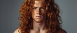 © The 2R Artificiality - A close-up shot of a young man with long, curly red hair and a muscular physique. The mans striking red hair is the focal point of the image, framing his face and drawing attention to his features.