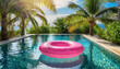 Pink Flamingo Floaty floating on swimming pool with palm trees and blue sky