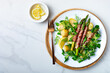 Spring salad with grilled green asparagus wrapped with bacon, boiled new baby potatoes, fresh corn salad leaves, lemon and mustard sauce