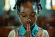 © wolfhound911 - African American school girl praying in church.