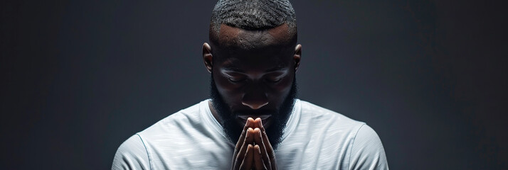 African American Man prays to god on black studio background