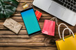An online shopping concept illustration that shows mobile phone devices gifts and e-commerce elements in a teal and crimson design, shopping online concept