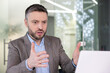 © Liubomir - Professional businessman in discussion gesturing at laptop in office setting