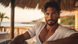 Handsome Latino man with model looks, relaxing on the beach in a private Ibiza villa.
