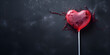 Lollipop candy in heart shape on dark blue background
