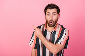 Poster - Portrait of speechless impressed man open mouth direct finger empty space isolated on pink color background