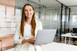 © Face Stock - Confident young businesswoman exudes casual professionalism, holds a laptop, ready to present or collaborate. Concept of a streamlined workflow and the mobility of modern work life