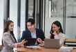 © Parichat - Motivated and smart business team working towards their goals together in the office room.