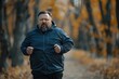 © เลิศลักษณ์ ทิพชัย - Overweight man smiles and jogs to maintain his health and lose weight from obesity in the park.