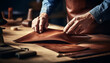 Master tanner sews a product from genuine leather