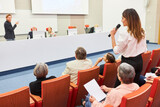 Fototapeta  - Audience asking question to orator at business conference in auditorium